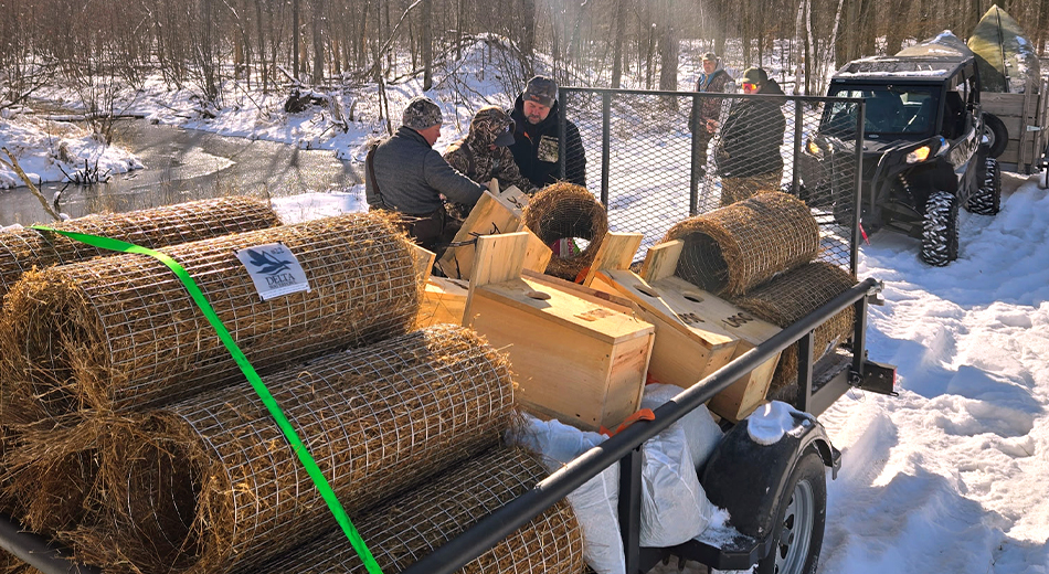 Hen houses in trailer with installers standing by